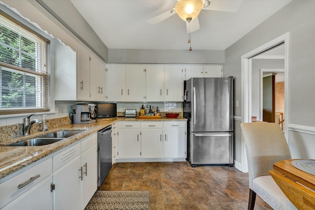 kitchen featuring white cabinetry, light stone counters, appliances with stainless steel finishes, and a sink