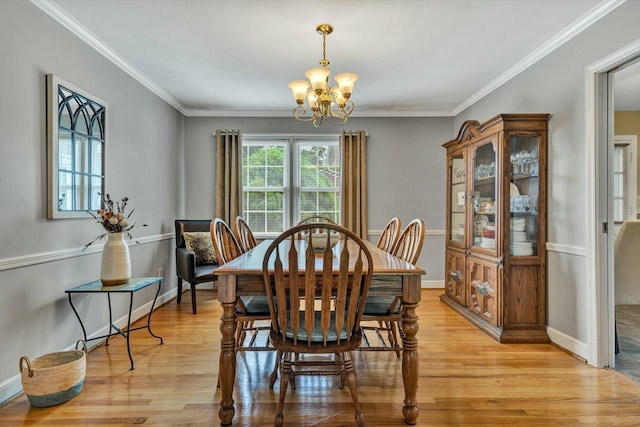 dining area with a notable chandelier, light wood-style flooring, baseboards, and ornamental molding