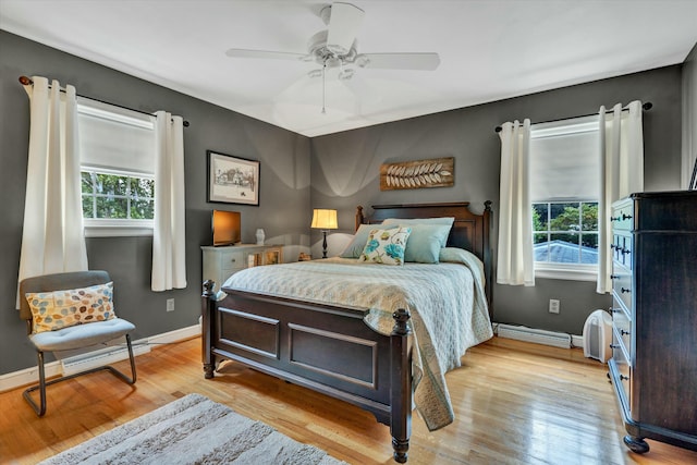 bedroom with baseboards, multiple windows, and light wood-style flooring