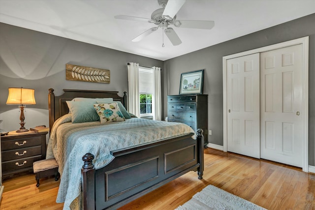 bedroom featuring light wood-type flooring, baseboards, a closet, and a ceiling fan