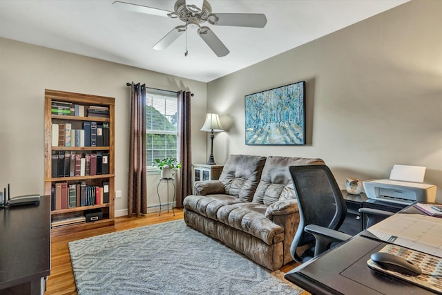 home office featuring a ceiling fan, wood finished floors, and baseboards