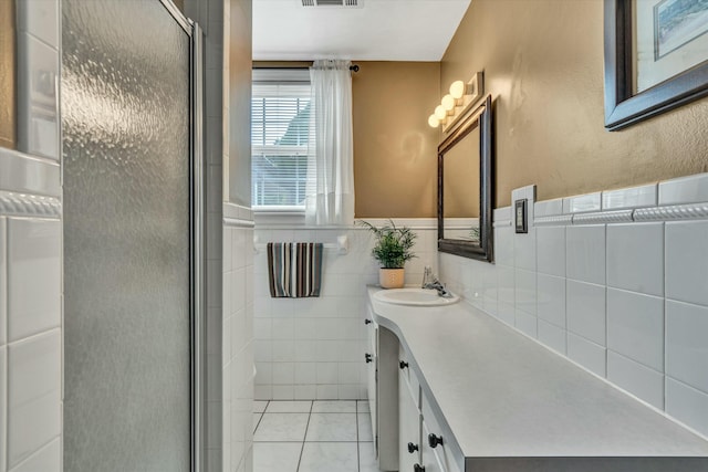 bathroom with vanity, visible vents, a stall shower, tile patterned flooring, and tile walls