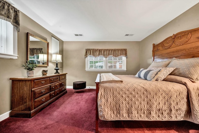 bedroom featuring visible vents, baseboards, and dark colored carpet