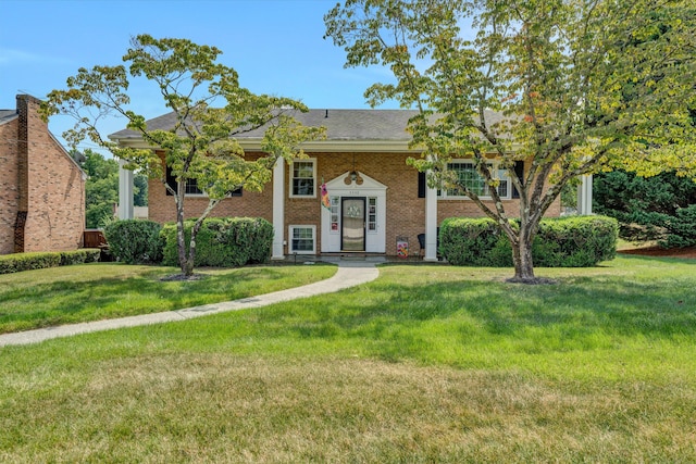 bi-level home with a front yard and brick siding