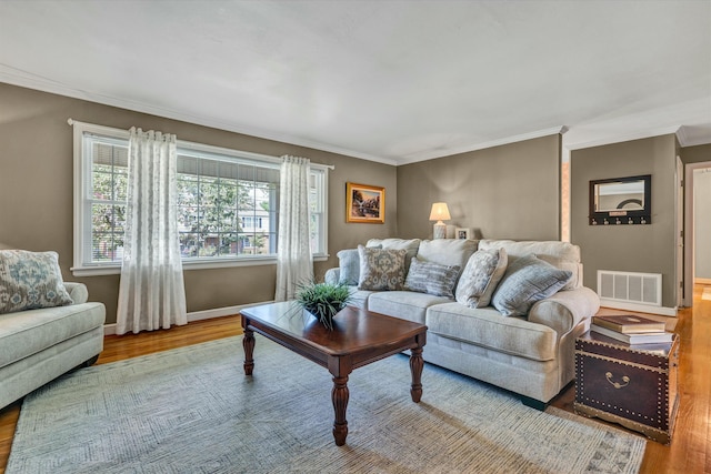 living area with visible vents, wood finished floors, and crown molding