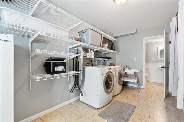 laundry room featuring washing machine and clothes dryer, laundry area, and baseboards