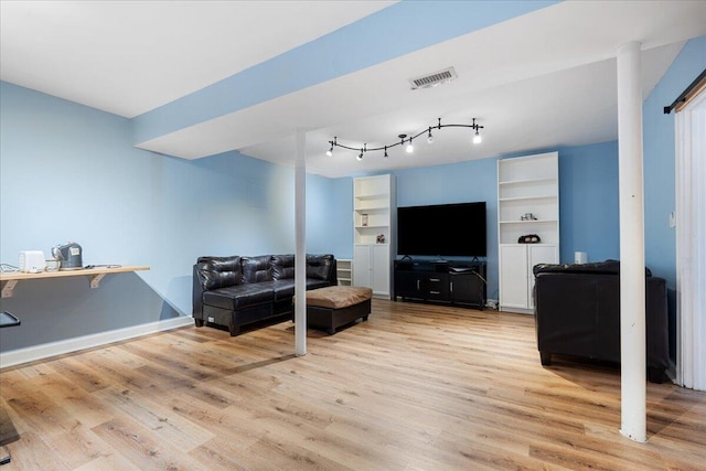 living area featuring visible vents, baseboards, and light wood-style floors