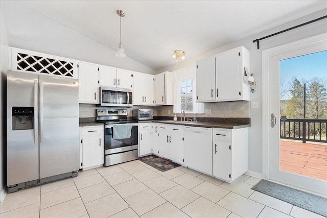 kitchen with decorative backsplash, dark countertops, hanging light fixtures, and appliances with stainless steel finishes