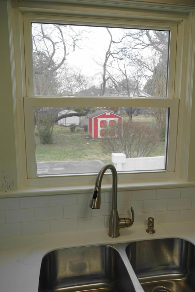 details featuring a sink, backsplash, and light countertops