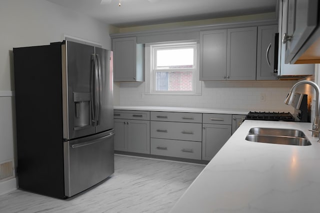 kitchen featuring marble finish floor, gray cabinets, appliances with stainless steel finishes, and a sink