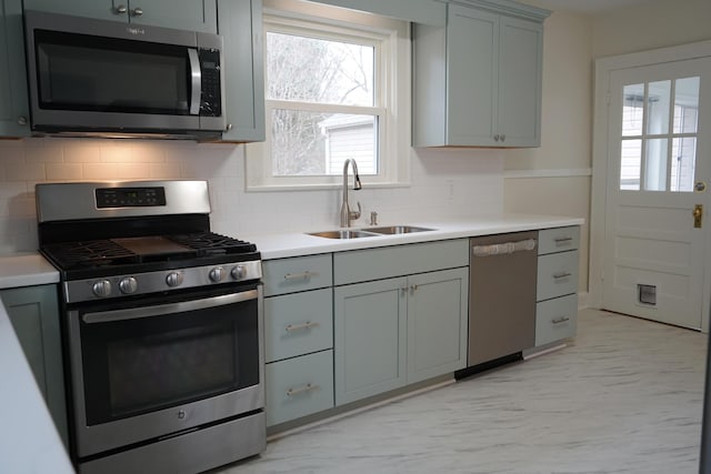 kitchen featuring a sink, light countertops, gray cabinets, and stainless steel appliances