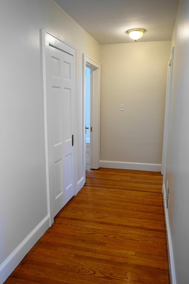 hallway with baseboards and wood finished floors