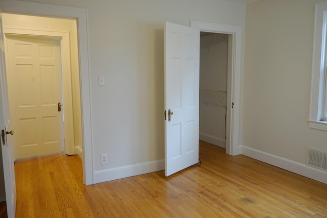 unfurnished bedroom with baseboards, visible vents, and light wood finished floors