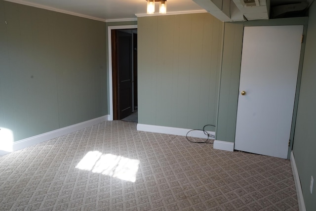 carpeted empty room with crown molding and baseboards