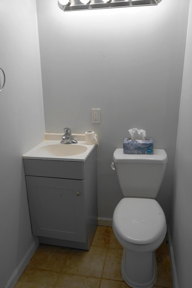 bathroom with baseboards, toilet, and vanity