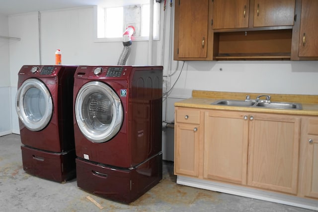 washroom with a sink, cabinet space, and separate washer and dryer