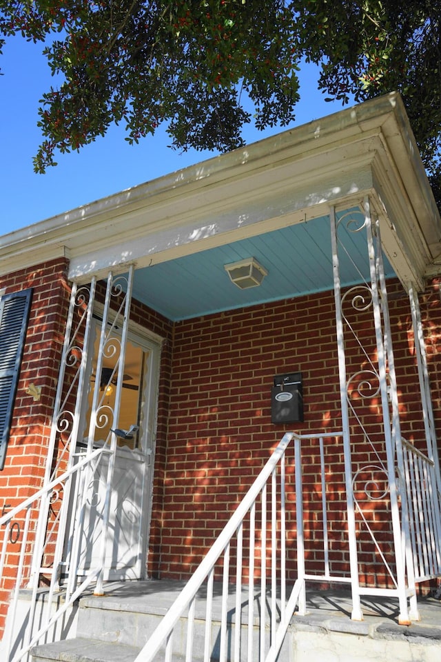 view of exterior entry featuring brick siding