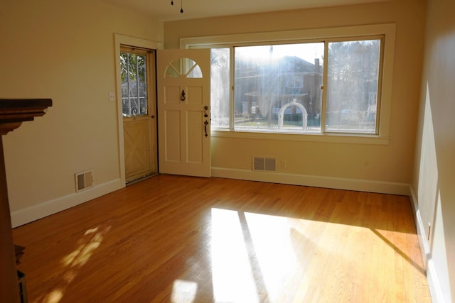 foyer with visible vents, baseboards, and wood finished floors