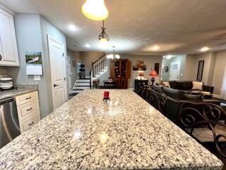 kitchen featuring white cabinetry, light stone countertops, and a kitchen island