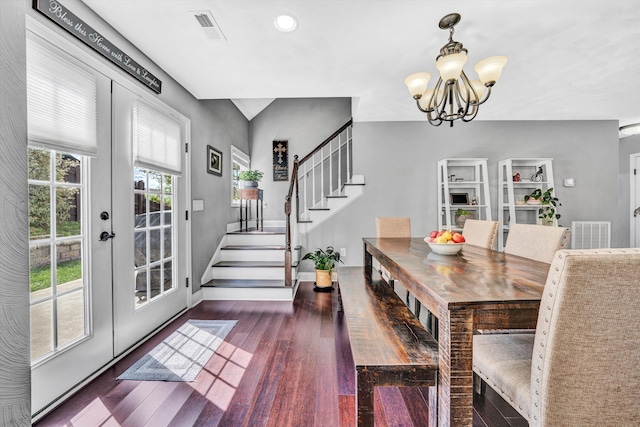 dining area featuring stairs, wood finished floors, a chandelier, and visible vents