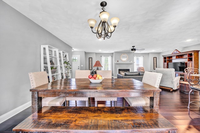 dining room featuring recessed lighting, a fireplace, baseboards, a chandelier, and dark wood-style flooring