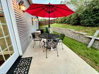 view of patio featuring outdoor dining area and fence