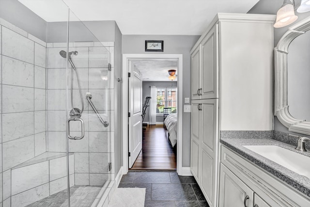 ensuite bathroom with vanity, baseboards, connected bathroom, and a shower stall