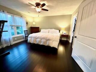 bedroom featuring a ceiling fan, wood finished floors, and baseboards