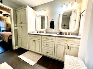 full bath featuring double vanity and ensuite bathroom