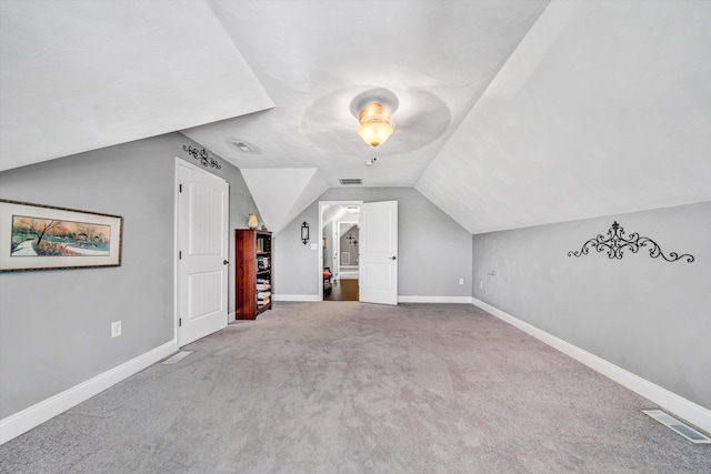 additional living space featuring lofted ceiling, carpet flooring, visible vents, and baseboards
