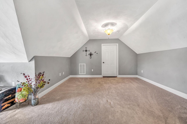 bonus room with lofted ceiling, baseboards, visible vents, and carpet