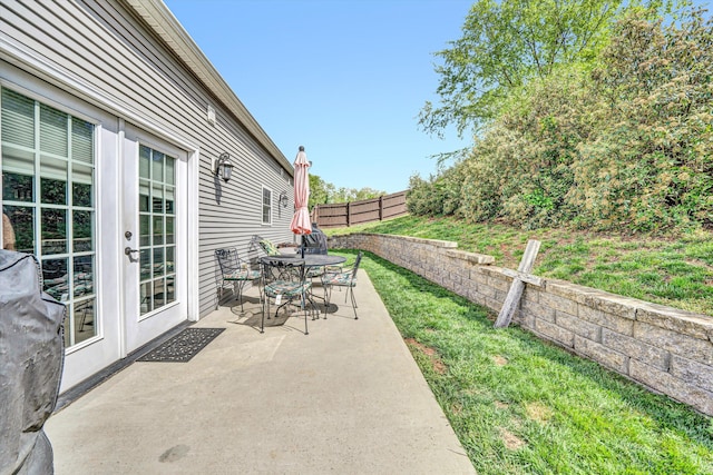 view of patio featuring a fenced backyard, french doors, and outdoor dining space