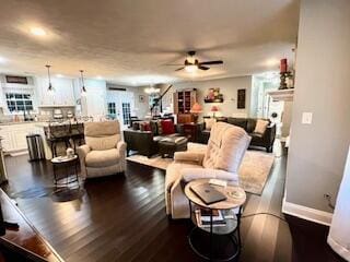 living area featuring baseboards, a fireplace, ceiling fan, and dark wood finished floors