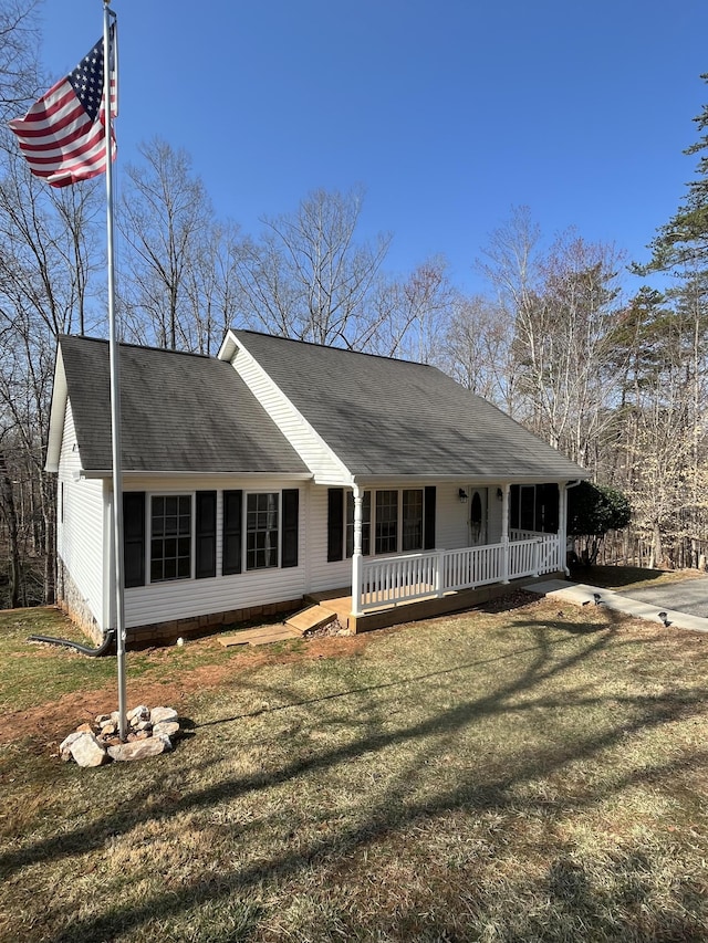 ranch-style home with crawl space, covered porch, a shingled roof, and a front lawn