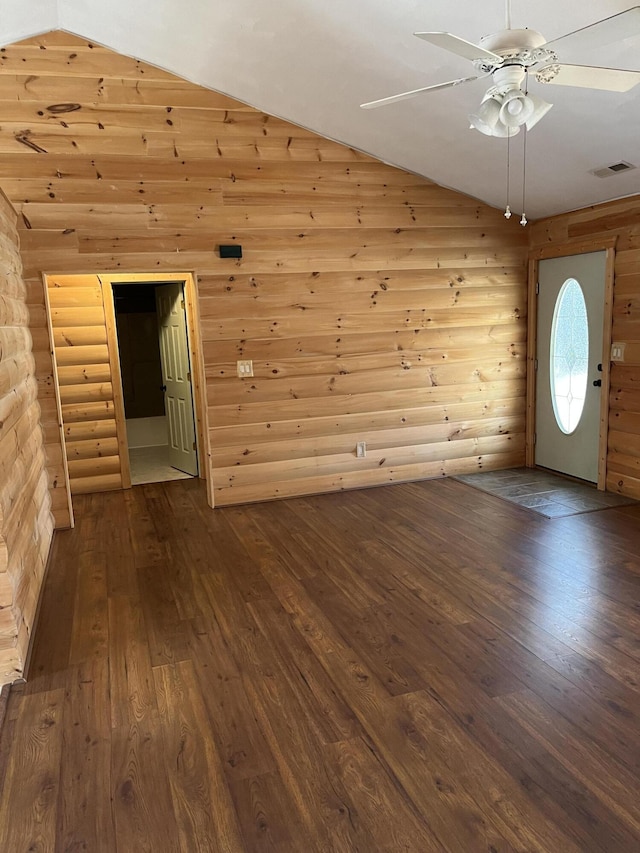 interior space featuring visible vents, a ceiling fan, log walls, lofted ceiling, and dark wood-style flooring