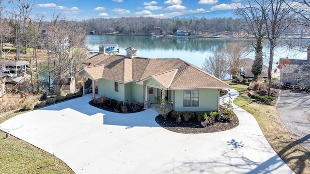 view of front of property with a water view, driveway, and a chimney