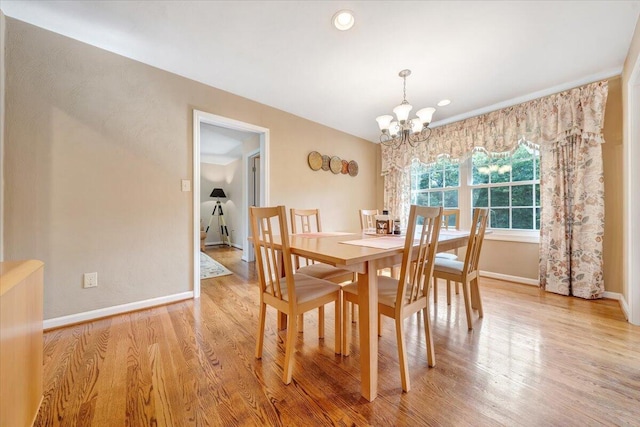 dining room with recessed lighting, baseboards, a notable chandelier, and light wood finished floors