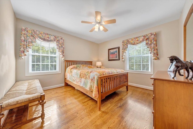 bedroom with light wood finished floors, ceiling fan, and baseboards