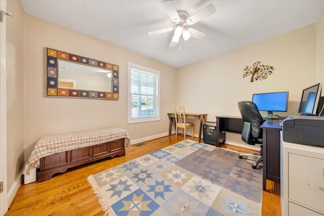 office featuring light wood finished floors, visible vents, baseboards, and a ceiling fan