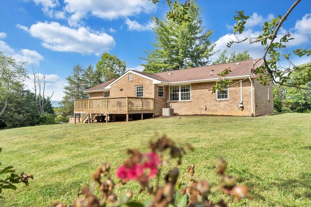 rear view of house with a deck, central air condition unit, a lawn, and brick siding