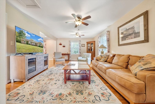 living area featuring light wood-style flooring and a ceiling fan