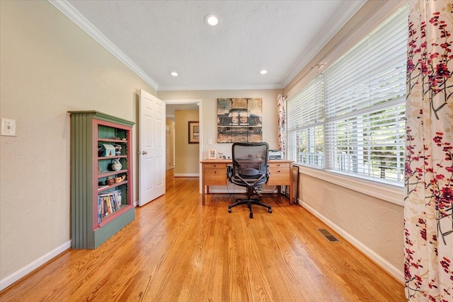 office featuring light wood-type flooring, visible vents, ornamental molding, baseboards, and a textured wall