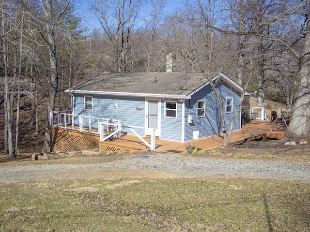 view of front facade featuring a front lawn and a wooden deck