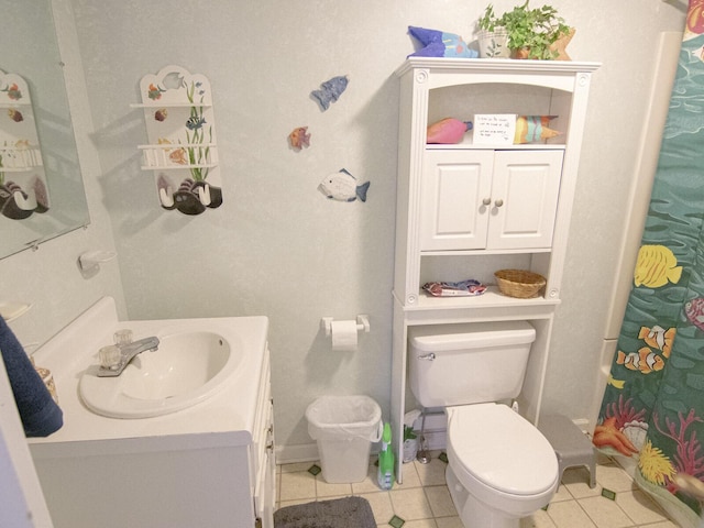 bathroom featuring vanity, a shower with shower curtain, baseboards, tile patterned floors, and toilet