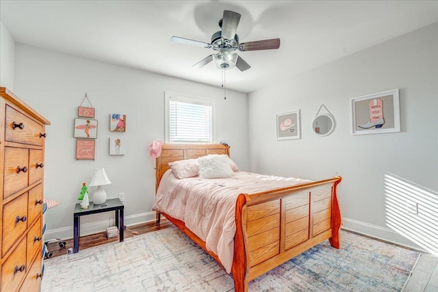 bedroom with baseboards, a ceiling fan, and light wood finished floors