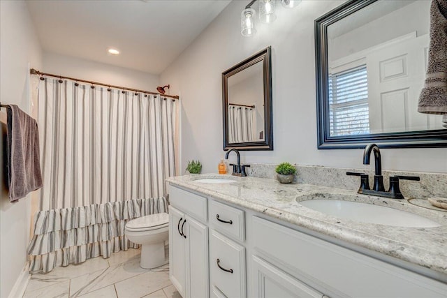 bathroom featuring double vanity, marble finish floor, toilet, and a sink