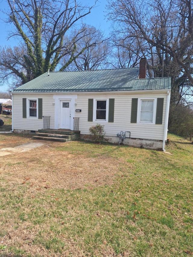 ranch-style home featuring a chimney, crawl space, metal roof, and a front lawn