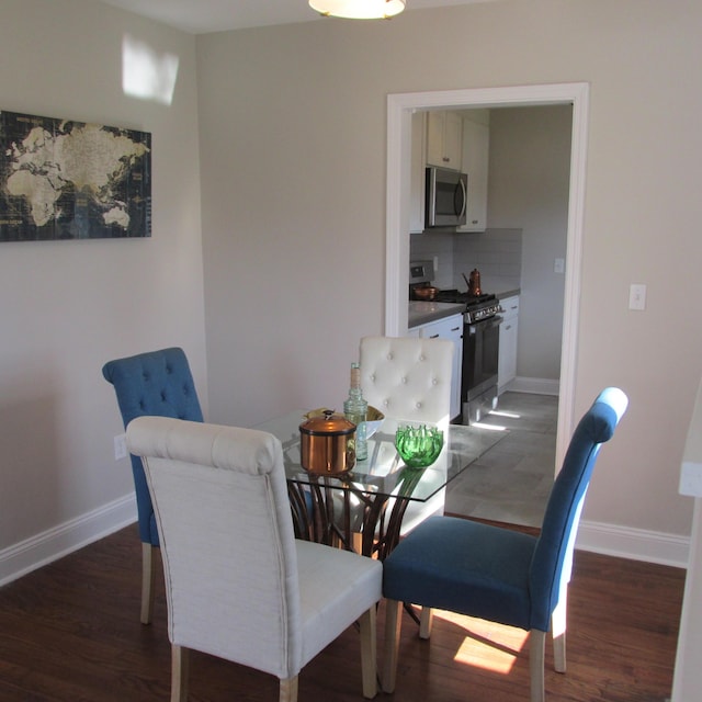 dining space featuring baseboards and wood finished floors