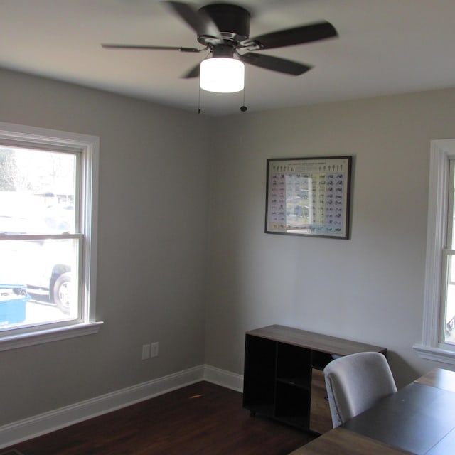 unfurnished office with a ceiling fan, baseboards, and dark wood-style flooring