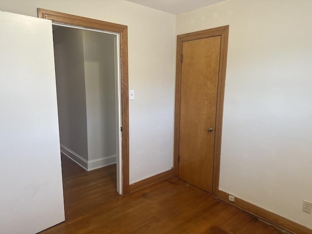 spare room featuring wood finished floors and baseboards